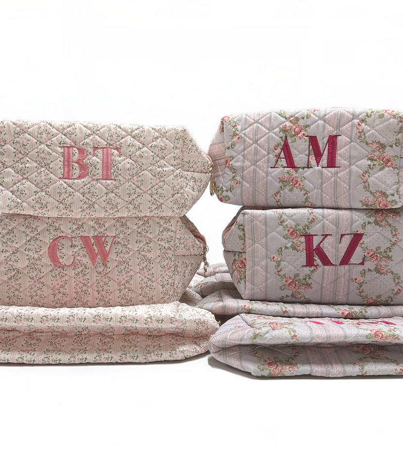Stack of quilted products with monogrammed initials on a white background
